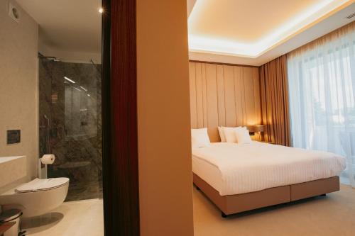 um quarto com uma cama e uma casa de banho com um chuveiro em Hotel Stein Collection em Timişoara