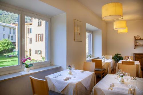a restaurant with two tables and a window at Hotel Romanda in Levico Terme