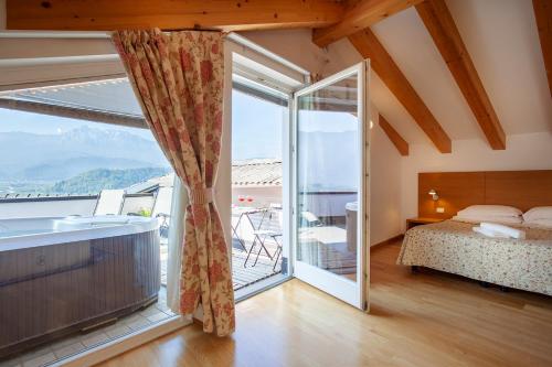 a bedroom with a bed and a large window at Hotel Romanda in Levico Terme