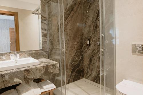 a bathroom with a shower and a sink at Hotel Stein Collection in Timişoara