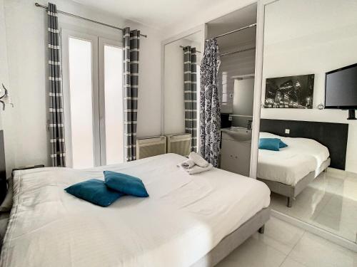une chambre avec deux lits et un miroir dans l'établissement Luxueux appartements idéalement situés en plein centre ville de Cannes, à Cannes
