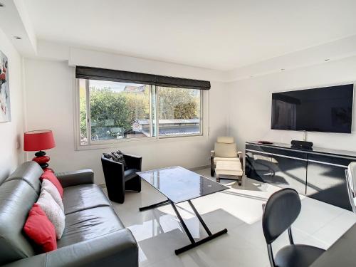 un salon avec un canapé et une télévision dans l'établissement Luxueux appartements idéalement situés en plein centre ville de Cannes, à Cannes