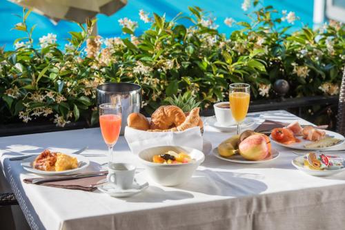 a table with plates of food and glasses of orange juice at Parkhotel Delta, Wellbeing Resort in Ascona