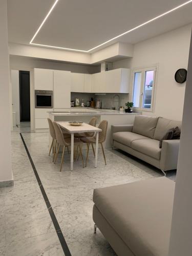 eine Küche und ein Wohnzimmer mit einem Sofa und einem Tisch in der Unterkunft Villetta Gramsci, Alassio in Alassio