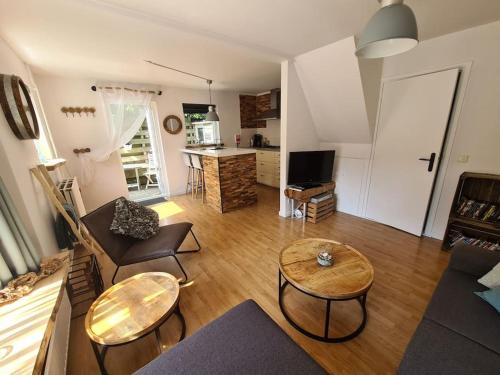 a living room with a couch and tables and a kitchen at Have a nice stay! - North Sea Home in Noordwijk aan Zee