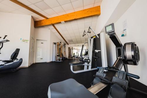 a gym with treadmills and machines in a room at Le Phare in Les Portes