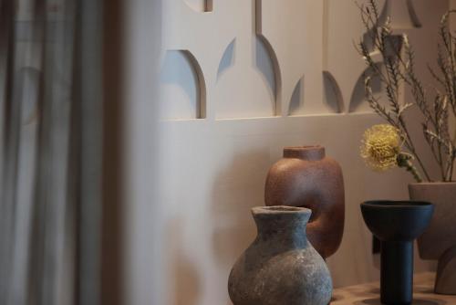 a group of vases sitting on a table next to a wall at Helea Lifestyle Beach Resort in Kallithea Rhodes