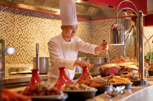 a chef preparing food in a restaurant kitchen at InterContinental Grand Ho Tram in Ho Tram