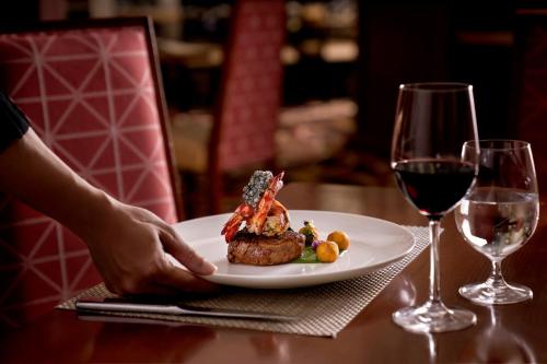 a plate of food on a table with a glass of wine at InterContinental Grand Ho Tram in Ho Tram