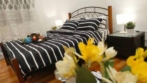 a black and white bed in a room with yellow flowers at ISLAMIC HOMESTAY @ KUALA ROMPIN , PAHANG . in Kuala Rompin