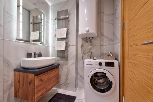 a bathroom with a washing machine and a sink at Mount Inn Gold in Zlatibor