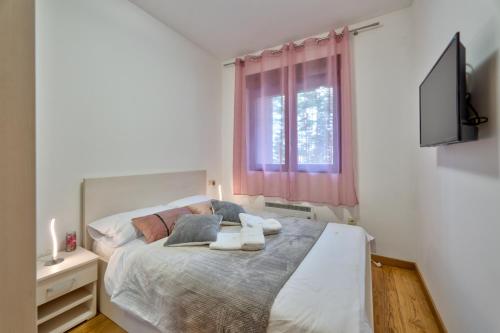 a bedroom with a bed with two towels on it at Mount Inn Gold in Zlatibor