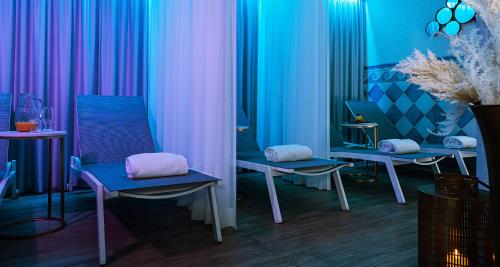 a room with blue and pink curtains and chairs at Victor's Residenz-Hotel Saarbrücken in Saarbrücken