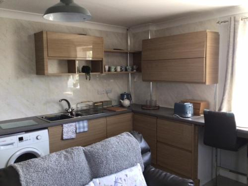 a small kitchen with a sink and a stove at Letterston Valley View in Haverfordwest