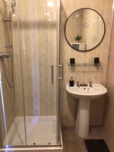 a bathroom with a shower and a sink and a mirror at Letterston Valley View in Haverfordwest