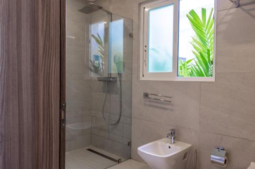 a bathroom with a shower and a sink and a window at Family Getaway Apartment - Right On The Beach in Punta Cana