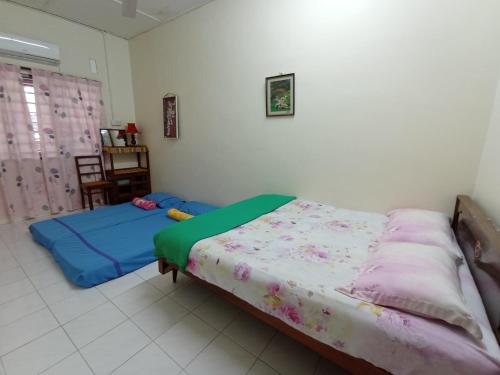 a bedroom with two beds in a room at Heawood Homestay Sungai Siput in Sungai Siput