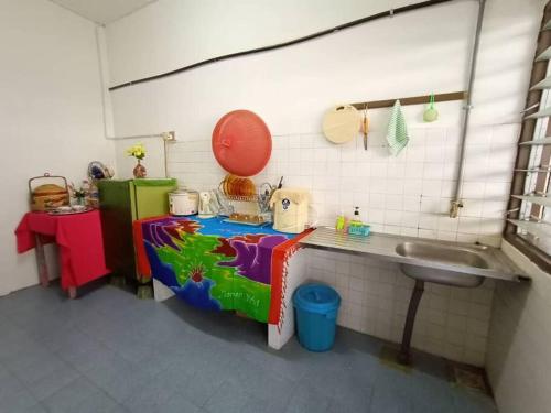 a small kitchen with a sink and a table at Heawood Homestay Sungai Siput in Sungai Siput