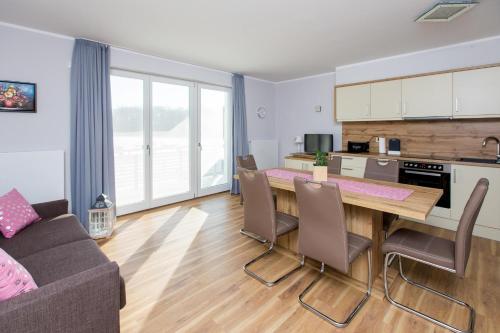 uma cozinha e sala de estar com mesa e cadeiras em Apartment am Yachthafen Whg 8 optional Bootsplatz em Plau am See