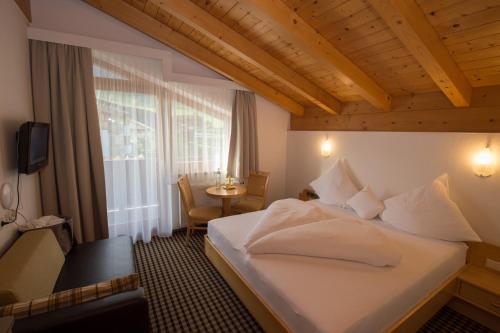 Habitación de hotel con cama y ventana en Hotel Tristkogel, en Saalbach Hinterglemm