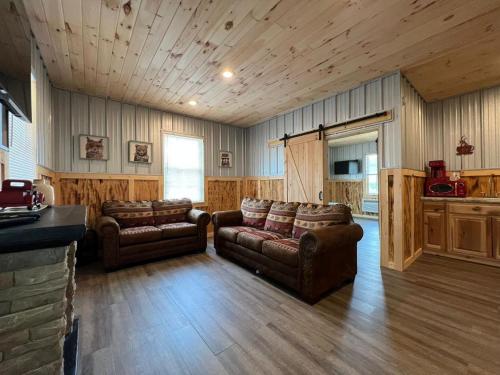 Brushcreek Falls RV Resort في برنستون: غرفة معيشة بأثاث جلدي ومطبخ