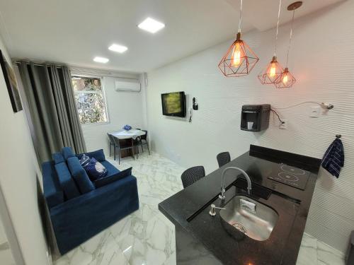 a living room with a sink and a blue couch at Angra Inn, Angra dos Reis - Mar, Sol e Piscina in Angra dos Reis