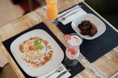 a table with two plates of food and a drink at Hotel MeraPrime Gold Lisboa in Lisbon