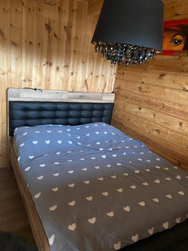 Bett in einem Zimmer mit einer Holzwand in der Unterkunft Sodo namelis 