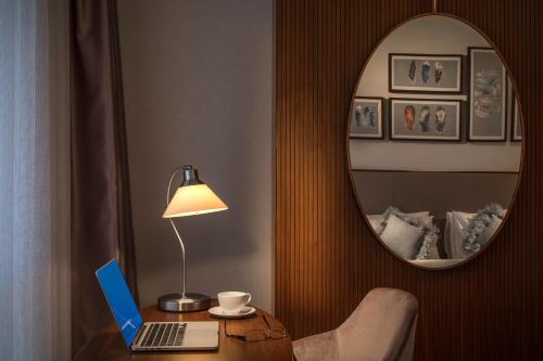 a room with a table with a laptop and a mirror at Lionel Hotel Istanbul in Istanbul