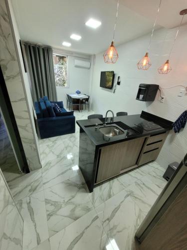 a kitchen with a sink and a living room at Angra Inn, Angra dos Reis - Mar, Sol e Piscina in Angra dos Reis