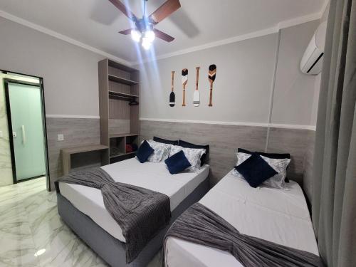 a bedroom with two beds and a ceiling fan at Angra Inn, Angra dos Reis - Mar, Sol e Piscina in Angra dos Reis