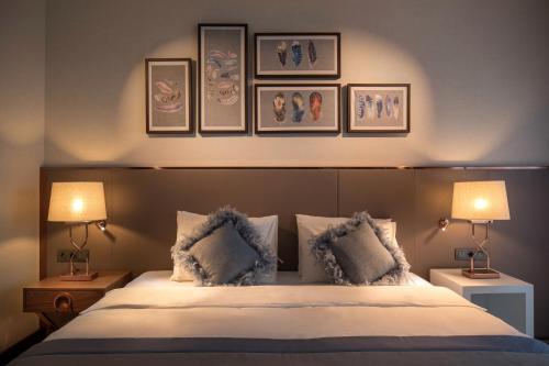 a bedroom with a bed with three pictures on the wall at Lionel Hotel Istanbul in Istanbul