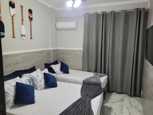 two beds in a room with knife and fork on the wall at Angra Inn, Angra dos Reis - Mar, Sol e Piscina in Angra dos Reis