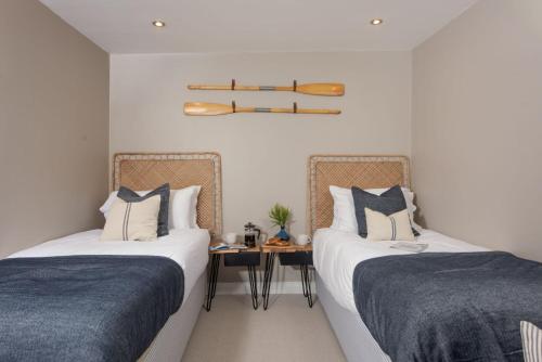 2 Betten in einem Zimmer mit einem Tisch dazwischen in der Unterkunft Sullivans Loft in Newlyn