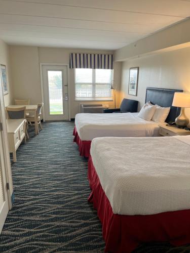 a hotel room with two beds and a desk at Dunes Suites Oceanfront in Ocean City