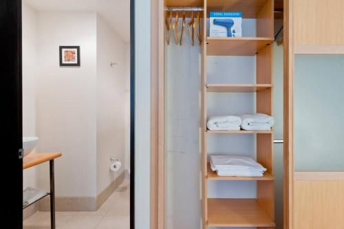 a closet with wooden shelves and white towels at Amazing Location Behind Hilton Hotel in Mexico City