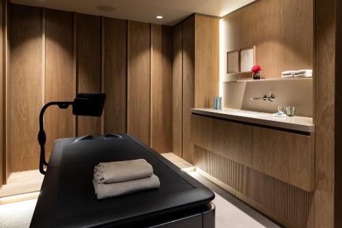 a bathroom with a black bench and a sink at Pillows Grand Boutique Hotel Maurits at the Park - Small Luxury Hotels in Amsterdam