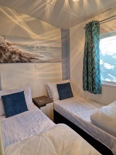 two beds in a room with a painting on the wall at Ocean view in Paignton