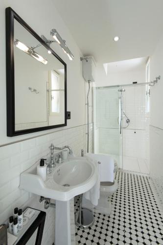 a bathroom with a sink and a toilet and a mirror at Relais Uffizi in Florence