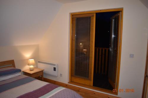 a bedroom with a bed and a window with a television at Erne River Lodge in Belturbet