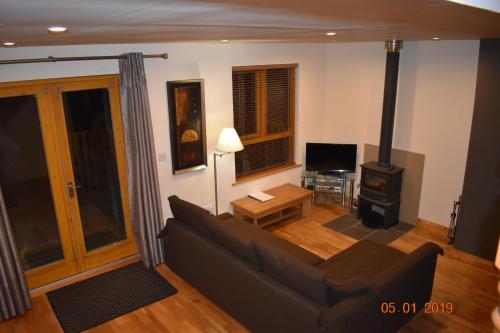 a living room with a couch and a wood stove at Erne River Lodge in Belturbet