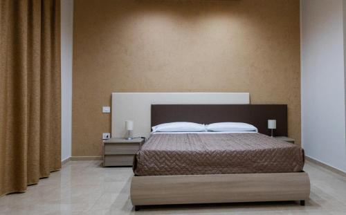 a bedroom with a bed with two night stands and two lamps at Agri-Resort Luxury Farm in Marigliano