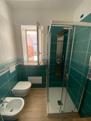 a bathroom with a toilet and a glass shower at Dimora Leone in Diamante