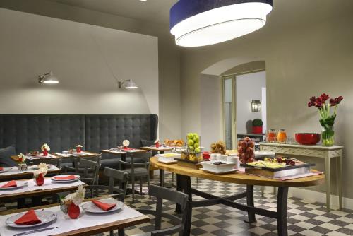 a restaurant with tables and chairs with food on them at Hotel Garibaldi Blu - WTB Hotels in Florence