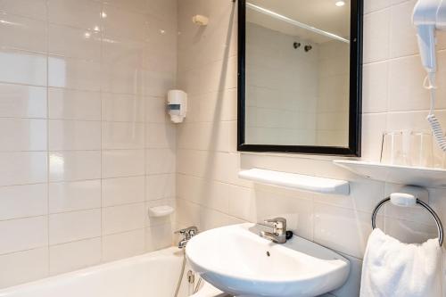 a white bathroom with a sink and a bath tub at Ibiza Rocks Hotel - Adults Only in San Antonio