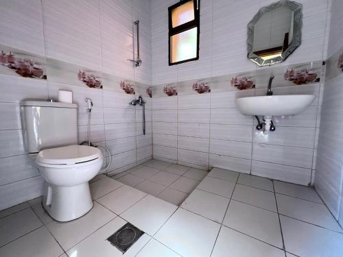 a white bathroom with a toilet and a sink at Bedouin Garden Village, hotel Dive in Aqaba