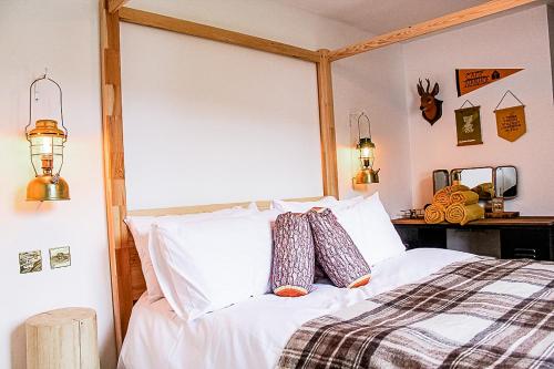 a bedroom with a bed with white sheets and pillows at This must be the place - Skye, Carbost in Carbost