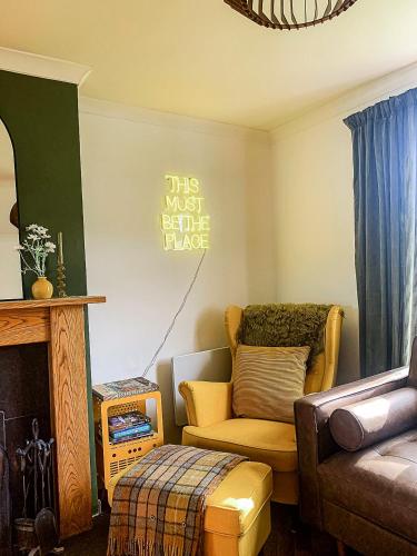 a living room with a couch and a chair at This must be the place - Skye, Carbost in Carbost