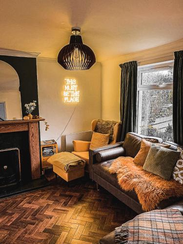 a living room with a couch and a fireplace at This must be the place - Skye, Carbost in Carbost