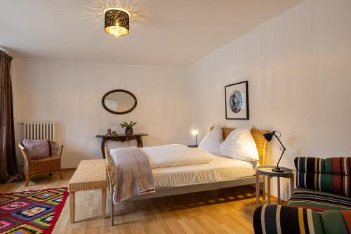 a bedroom with a bed and a chair at Gutsverwaltung Schloss Eyrichshof in Ebern